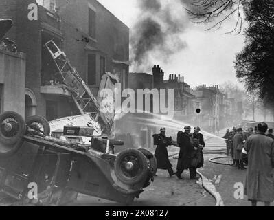 Feuerwehrleute reagieren auf eine simulierte Explosion während einer ARP-Übung in Portsmouth, Gosport und Southampton am 25. Februar 1940 mit inszenierten Gefahren, darunter ein umgekipptes Auto und ein Scheinflugzeug der Luftwaffe. Stockfoto