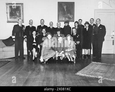 DIE NORWEGISCHE KÖNIGSFAMILIE WÄHREND DES ZWEITEN WELTKRIEGS – König Haakon, Prinzessin Marthe und ihre drei Kinder fotografierten in Rosyth, als sie sich auf die Rückkehr nach Oslo am Ende des Krieges vorbereiten. Gruppenfoto im Admiralty House in North Queensferry, bevor die königliche Party in der HMS NORFOLK begann. Von links nach rechts: Erste Sitzreihe: Prinzessin Astrid; Prinz Harald; Prinzessin Ragnhild. Mittlere Reihe: Lady Whitworth; HM King Haakon; HRH Kronprinzessin Marthe; Admiral Sir William J Whitworth, KCB, DSO, Commander in Chief Rosyth. Hintere Reihe: Kapitän (S) F R J Mack, CBE, RN; Kapitän J E Jacabsen, R NOR N; Kapitän R B. Stockfoto