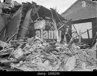 LONDON ZEIGT DIE FLAGGE: DAS LEBEN GEHT WEITER IN KRIEGSZEITEN LONDON, ENGLAND, 1940 - Eine Krönungstafel, Die zuletzt 1937 ausgestellt wurde, wird von Bergungsarbeitern auf einem Schutthaufen aufgehängt, wo einst ein Haus stand, um Passanten daran zu erinnern, dass London es nehmen kann. Stockfoto