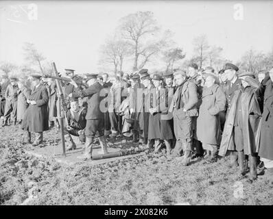 DEMS-SCHÜTZEN HALTEN PACE MIT DEN NEUESTEN KRIEGSWAFFEN. 11. UND 12. NOVEMBER 1943, DEMS RANGES, CARDIFF. DAS DEMS-TRAININGSZENTRUM, IN DEM DIE MÄNNER, DIE FEINDLICHE SEE- UND LUFTANGRIFFE AUF ALLIIERTE HANDELSSCHIFFE ABWEHREN, AUFFRISCHUNGSKURSE ABSOLVIEREN, UM PACE MIT IHREN NEUEN VERTEIDIGUNGSWAFFEN ZU VERSORGEN. - Der Wert der Tracerkugel, die demonstriert wird. Zuhören und zuschauen sind Männer aus Holland, Norwegen, Amerika und England. Der Kumpel des Chief Gunner CPO C F H Pitman feuert und gibt Ratschläge für die DEMS-Bewertung Stockfoto