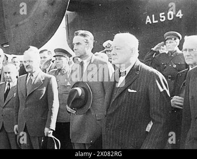 DIE ZWEITE MOSKAUER KONFERENZ, AUGUST 1942 - Herr Churchill, der von dem sowjetischen Außenminister Molotow bei der Ankunft am Moskauer Flughafen begrüßt wurde, steht barköpfig, während Bands der Roten Armee die Nationalhymnen Großbritanniens, der USA und der UdSSR spielen, 12. August 1942.William Averell Harriman, der US-Sondergesandte für Europa; Wjatscheslaw Molotow, der sowjetische Außenkommissar; und Boris Shaposchnikow, der stellvertretende sowjetische Verteidigungskommissar, steht rechts vom Premierminister. Hinter einem Teil des Schwanzes des riesigen Liberator-Bombers, mit dem Churchill nach Moskau flog, ist Churchill, Winston Leonard SPE zu sehen Stockfoto