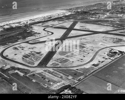 ROYAL AIR FORCE COASTAL COMMAND, 1939-1945. - Schrägansicht vom Flughafen Squires Gate, Blackpool, Lancashire, aus Südosten. Im Vordergrund und auf beiden Seiten der von der Leach Lane (rechts) verlaufenden Bahnstrecke sind Boulton-Paul Defiants der No. 256 Squadron RAF und eine Abteilung der No. 96 Squadron RAF zu sehen. Ebenfalls sichtbar im linken Vorfeld und an anderen Teilen des Flugplatzes sind Avro Ansons und Boulton Paul Bothas von der No. 3 School of General Reconnaissance Royal Air Force, 1 Camouflage Unit, Royal Air Force, Wing, 297, Royal Air Force, 96 Squadron, Royal Air Force, 3 School o Stockfoto