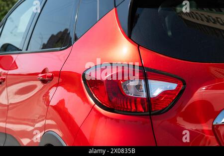 Nahaufnahme des Rücklichts an der roten Car Captur, die auf der Straße geparkt ist. Selektiver Fokus Stockfoto