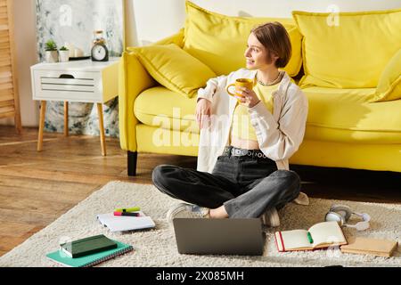 Eine junge Frau sitzt friedlich auf dem Boden, in Gedanken vertieft, während sie eine dampfende Tasse Kaffee hält. Stockfoto