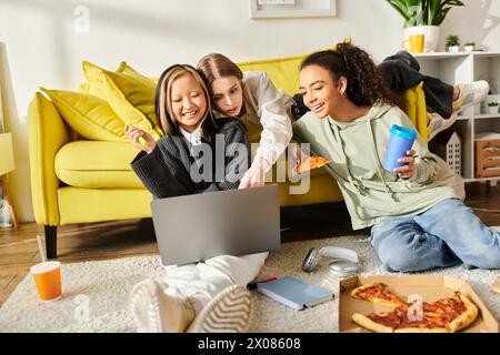 Eine lebendige Gruppe junger Frauen verschiedener Ethnien, die auf einem Stockwerk neben einer stilvollen gelben Couch sitzen und sich mit Lachen und Bindungen teilen. Stockfoto