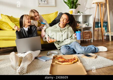 Verschiedene Teenager-Mädchen sitzen zusammen auf dem Boden und genießen Pizza in gemütlicher Atmosphäre. Stockfoto