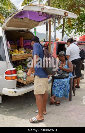 In Port Elizabeth, Bequia Island, St. Vincent und den Grenadinen in der Karibik verkaufen die Einheimischen Obst und Gemüse aus dem Kofferraum ihres Autos Stockfoto