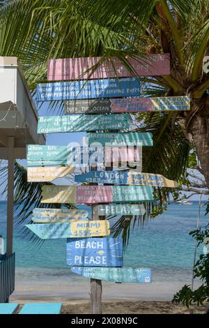 Farbenfroh gemalte Wegweiser in Keegan's Beach Bar und Restaurant, Lower Bay Beach, Bequia Island, St. Vincent und die Grenadinen, Karibik Stockfoto