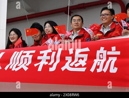 (240410) -- QINGDAO, 10. April 2024 (Xinhua) -- Mitglieder des Expeditionsteams schwenken Flaggen auf dem Eisbrecher Xuelong in einem Hafen in Qingdao, ostchinesischer Provinz Shandong, 10. April 2024. Chinas Forschungseisbrecher Xuelong kam am Mittwoch nach Abschluss seiner letzten Antarktis-Expedition in einem Hafen in Qingdao an und wird dort ein dreitägiges Open House für die Öffentlichkeit beherbergen. Chinas 40. Antarktis-Expeditionsteam brach am 1. November von Shanghai aus auf. 2023 und erfolgreich verschiedene Expeditionsaufgaben, die 161 Tage dauerten, mit insgesamt mehr als 81.000 Seemeilen. (Xinhua/Li Ziheng) Stockfoto