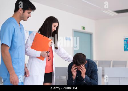 Mediziner sprechen mit Patienten, die traurig sind und im Krankenhaus den Kopf halten. Stockfoto