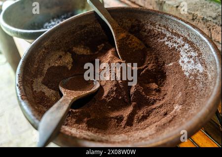 Traditioneller gemahlener Kaffee in einer rustikalen Schüssel mit einem Löffel, gefangen in Bali, Indonesien, zeigt die reiche Textur und das Aroma des lokalen balinesischen Kaffees Stockfoto