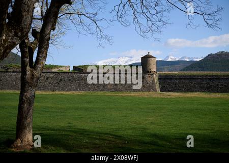 Die alten Mauern und die Bastion der Ciudadela de Jaca stehen stolz vor dem Hintergrund schneebedeckter Berge unter einem klaren blauen Himmel in Huesca, Spa Stockfoto