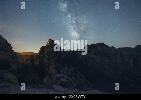 Ein atemberaubender Blick auf einen Sternenhimmel über zerklüfteten Berggipfeln, perfekt für Outdoor- und Wanderthemen Stockfoto