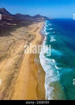 Atemberaubende Luftaufnahme, die die weite, sandige Weite des Cofete Beach mit unberührtem türkisfarbenem Wasser entlang Fuerteventuras zerklüfteter Küste, Showcasi, erfasst Stockfoto