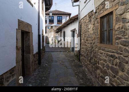 Kopfsteinpflasterstraße, flankiert von traditionellen Steinhäusern in Potes, Kantabrien, Spanien. Stockfoto