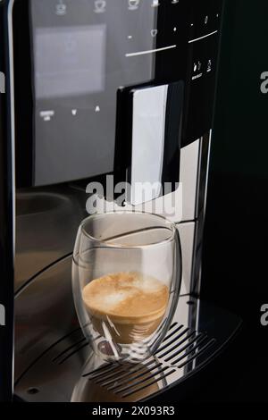 Moderne automatische Kaffeemaschine mit frisch gebrühtem Kaffee in einer Glasschale. Küchengeräte Stockfoto