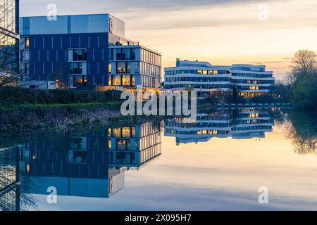 Northampton, Northamptonshire, Großbritannien - April 2023: Die Gebäude des Northampton University Waterside Campus spiegeln sich bei Sonnenuntergang im Fluss Nene. Stockfoto