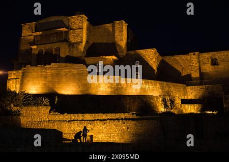 Coricancha und das Kloster von Santo Domingo in Cusco Peru werden abends beleuchtet, während Touristen und Touristen die Silhouetten sehen Stockfoto