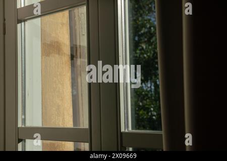 Doppelt verglaste Fenster mit Licht- und Transparenzeffekten, die Sonnenreflexionen heben die Struktur des Fensters und seine besondere wichtige Ele hervor Stockfoto