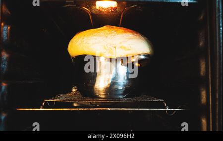 Eine Nahaufnahme des Sauerteigs im Ofen für köstliches hausgemachtes Brot, das den Backprozess und die Kunst des Backens demonstriert. Stockfoto