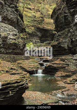 rainbow Falls im watkins glen State Park (Wasserfall in einer Schlucht mit Steinbrücke, Treppe, Gletschergesteinsgestein) fallendes Wasser, Bach Stockfoto