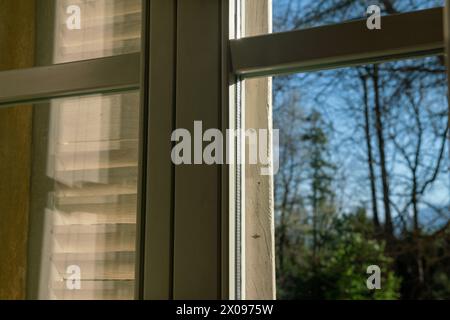 Doppelt verglaste Fenster mit Licht- und Transparenzeffekten, die Sonnenreflexionen heben die Struktur des Fensters und seine besondere wichtige Ele hervor Stockfoto