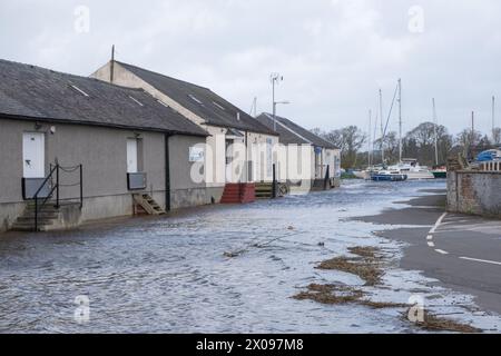 Hochwasser aus dem Fluss Nith gelangt am 7. April 2024 in das Dorf Kingholm Quay, Schottland, und beeinträchtigt Unternehmen und Verkehr. Stockfoto