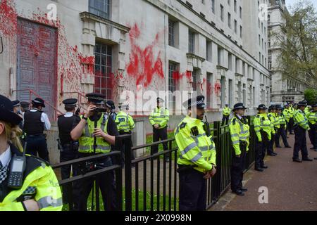 London, Großbritannien. April 2024. Die Polizei verhaftet Demonstranten während der Demonstration. Aktivistengruppen Palestine Action und Youth Demand spritzten rote Farbe über das Gebäude des Verteidigungsministeriums in Westminster. Die Gruppen fordern die britische Regierung auf, den Waffenverkauf an Israel einzustellen, während die Kämpfe in Gaza fortgesetzt werden. Quelle: SOPA Images Limited/Alamy Live News Stockfoto