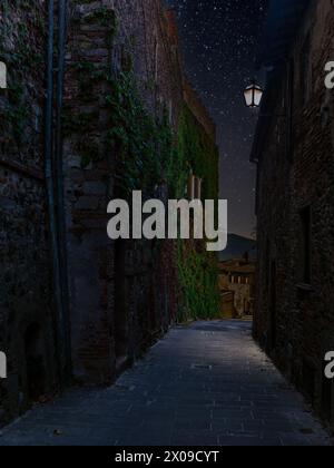 Die farbenfrohen mittelalterlichen Häuser und Gassen eines toskanischen Dorfes bei Nacht Stockfoto