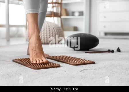 Sportliche junge Frau, die zu Hause auf Sadhu-Brett steht, Nahaufnahme Stockfoto