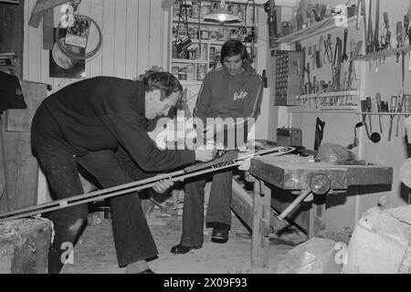 Aktuell 11 - 2 - 1974: Glasfaser med kunstnerhjelp Tre kjente kunstnere spilte en hovedrolle da Gjermund Eggen gikk på nye glassfiberski på 15 km Da de nye skiene viste seg å være for brede kontaktet Aktuells fotograf Ivar Aaserud billedhoggeren og tegneren Nils AAS og hans kone Tonje som også er tegner, samt kunstmaleren Frans Widerberg. Disse høvlet og malte Skiene rutschte bei de kunne Brukes Dagen etter. - Hektisk aktivitet i Niels AAS' Kunstnerverksted natta før 15 km AAS høvler med varsom hånd mens Eggen følger verbrachte med i arbeidet og med klokka. Foto; Ivar Aaserud / aktuell / NTB ***FOT Stockfoto