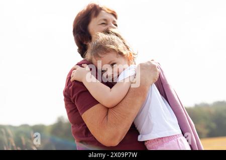 Die Wärme und Liebe eines kleinen Mädchens und ihrer Großmutter, umgeben von der Schönheit der Natur und der Ruhe der Landschaft Stockfoto