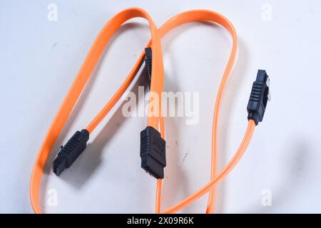 Nahaufnahme des orangefarbenen Serial ATA(SATA)-Kabels, das mit der Hauptplatine des Computers verbunden ist. SATA ist eine Schnittstelle zur Datenübertragung zwischen Hauptplatine und Massenspeicher Stockfoto