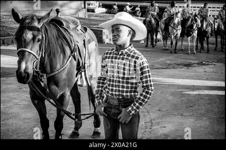 Little Rock, Arkansas, USA. April 2024. DAMON HOPKINS Jr. hält sich an seinem Pferd seines Vaters Damon Sr. Vor dem Grand in der zweiten jährlichen Niederlage des Beast Rodeo im Barton Coliseum in Little Rock, Arkansas Damon Sr. Gewann den Bronc Horse Competition. (Kreditbild: © Brian Branch Price/ZUMA Press Wire) NUR REDAKTIONELLE VERWENDUNG! Nicht für kommerzielle ZWECKE! Stockfoto