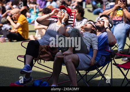 Atlanta, GA / USA - 8. April 2024: Eine Familie trägt eine spezielle Brille, um die totale Sonnenfinsternis bei einer Uhrenparty am 8. April 2024 in Atlanta, GA, zu sehen. Stockfoto