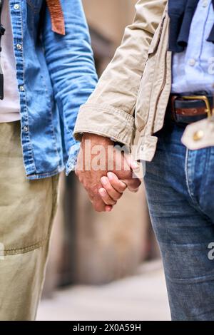 Nahaufnahme eines unerkennbaren erwachsenen Ehepaars, das sich im Freien an den Händen hält. Stockfoto