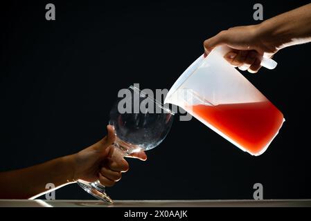 Guavasaft wird in einem Glasbecher serviert. Isoliert auf dunklem Hintergrund. Stockfoto