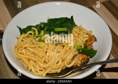 Hühnernudelsuppe in einer Tasse mit Untertasse und Löffel und Serviette Stockfoto