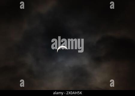 Partielle Sonnenfinsternis - Mond bedeckt Sonne, dunkle Wolken, himmlisches Drama - Halbmondsonne - atmosphärische Stimmung. Aufgenommen in Toronto, Kanada. Stockfoto