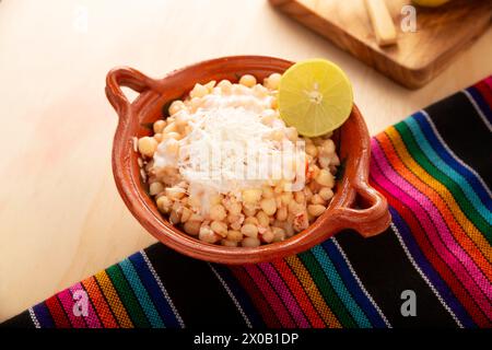 Esquites. Maiskerne gekocht und serviert mit Mayo, Sauerrahm, Zitronen- und Chilipulver, sehr populäres Street Food in Mexiko, auch bekannt als Elote en Vas Stockfoto