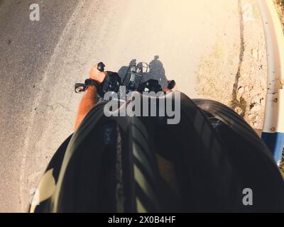 Vorne oben firts Person Sicht Fahrradlenker mit Straßenhintergrund. Radfahrer Tapete Hintergrund Stockfoto