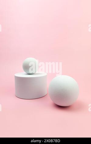 Weißes rundes Podium, weiße Kugeln auf rosafarbenem Hintergrund. Geometrische abstrakte Formen für die kosmetische Produktpräsentation. Kopierbereich. Stockfoto