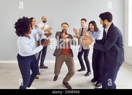 Glückliche, aufgeregte Geschäftsleute gruppieren Männer und Frauen, die Spaß im Büro haben, glücklich, einen guten Deal zu machen. Stockfoto