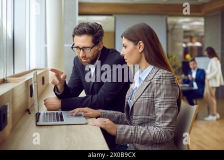 Männlicher Business Coach, der jungen Geschäftsfrau hilft, erfolgreich im Start-up navigiert Stockfoto