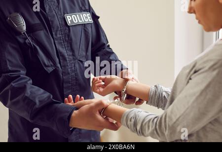 Nahaufnahme eines Polizisten, der Einer Verdächtigen oder Schuldigen Handschellen anlegt Stockfoto