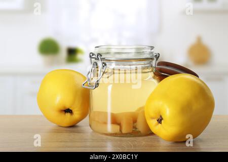 Köstliches Quittengetränk und frisches Obst auf Holztisch in der Küche Stockfoto