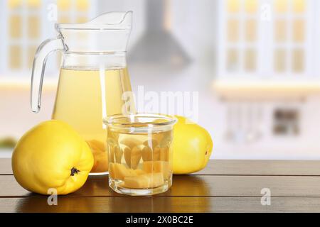 Köstliches Quittengetränk und frisches Obst auf Holztisch in der Küche. Leerzeichen für Text Stockfoto