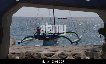 Ein traditionelles Boot, das tagsüber in einem Rahmen am Strand von Pasir Putih Situbondo liegt Stockfoto