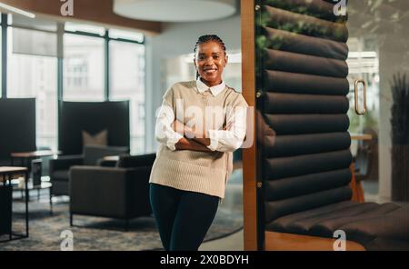 Erfolgreiche Geschäftsfrau, die in einem Coworking Office steht. Sie ist eine junge Unternehmerin und Managerin in einem professionellen, gemeinsam genutzten Arbeitsplatz. Die Frau ist es Stockfoto