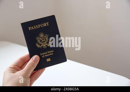 Nahaufnahme einer weiblichen Hand, die einen amerikanischen Pass hält, verschwommener Hintergrund Stockfoto